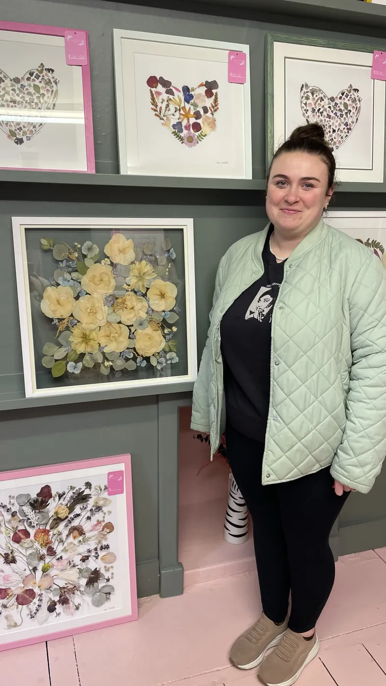 A happy bride with her framed pressed wedding bouquet