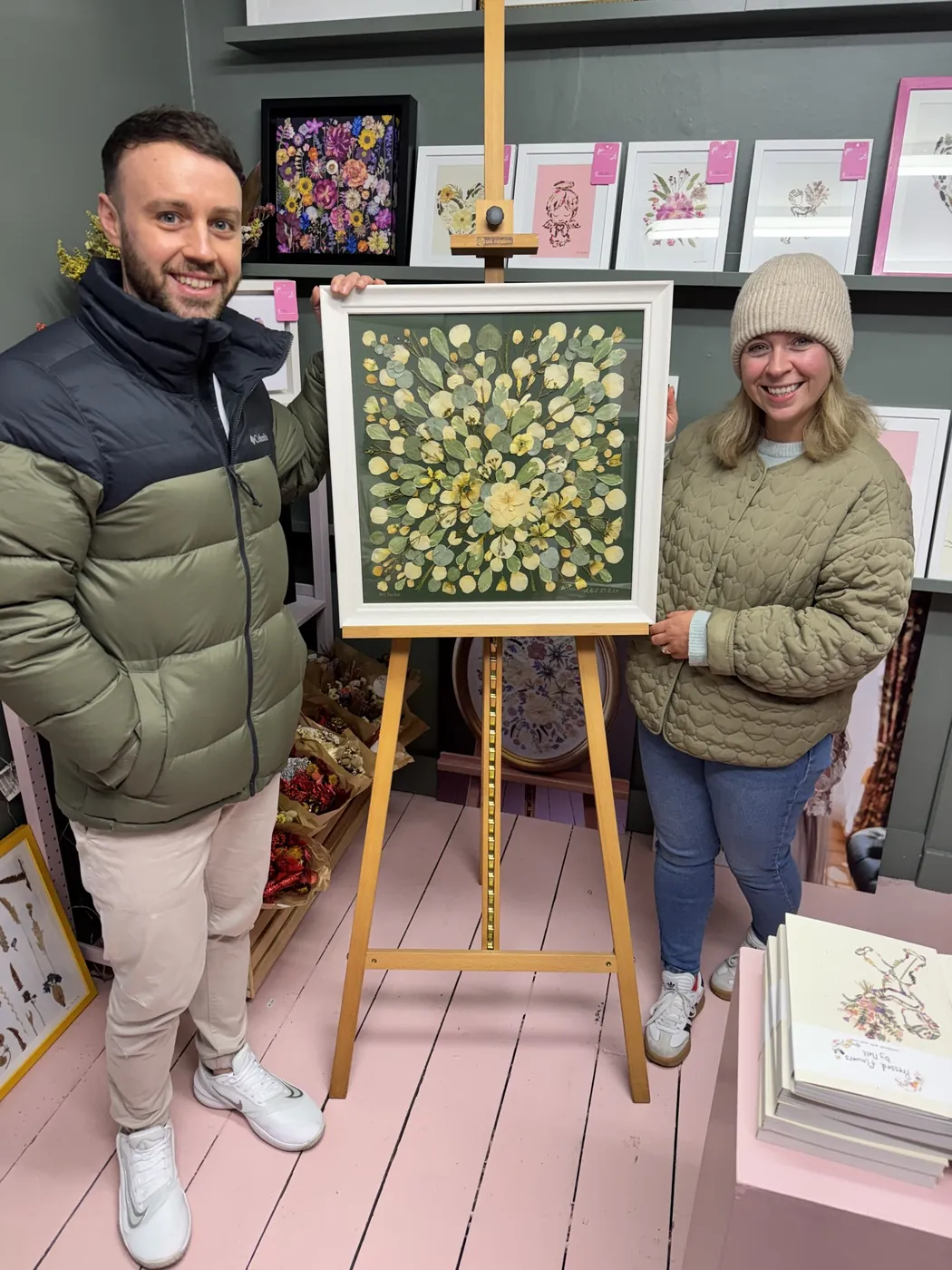 A happy bride with her framed pressed wedding bouquet