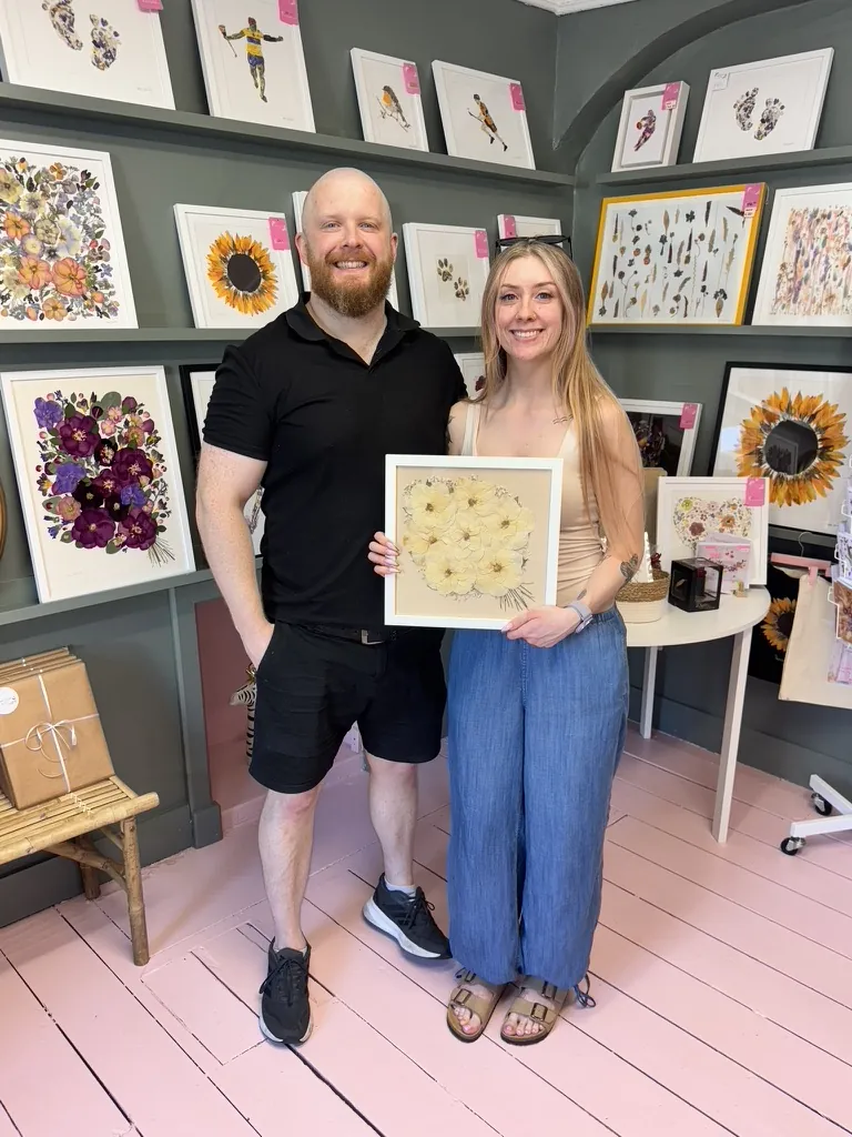 A happy bride with her framed pressed wedding bouquet