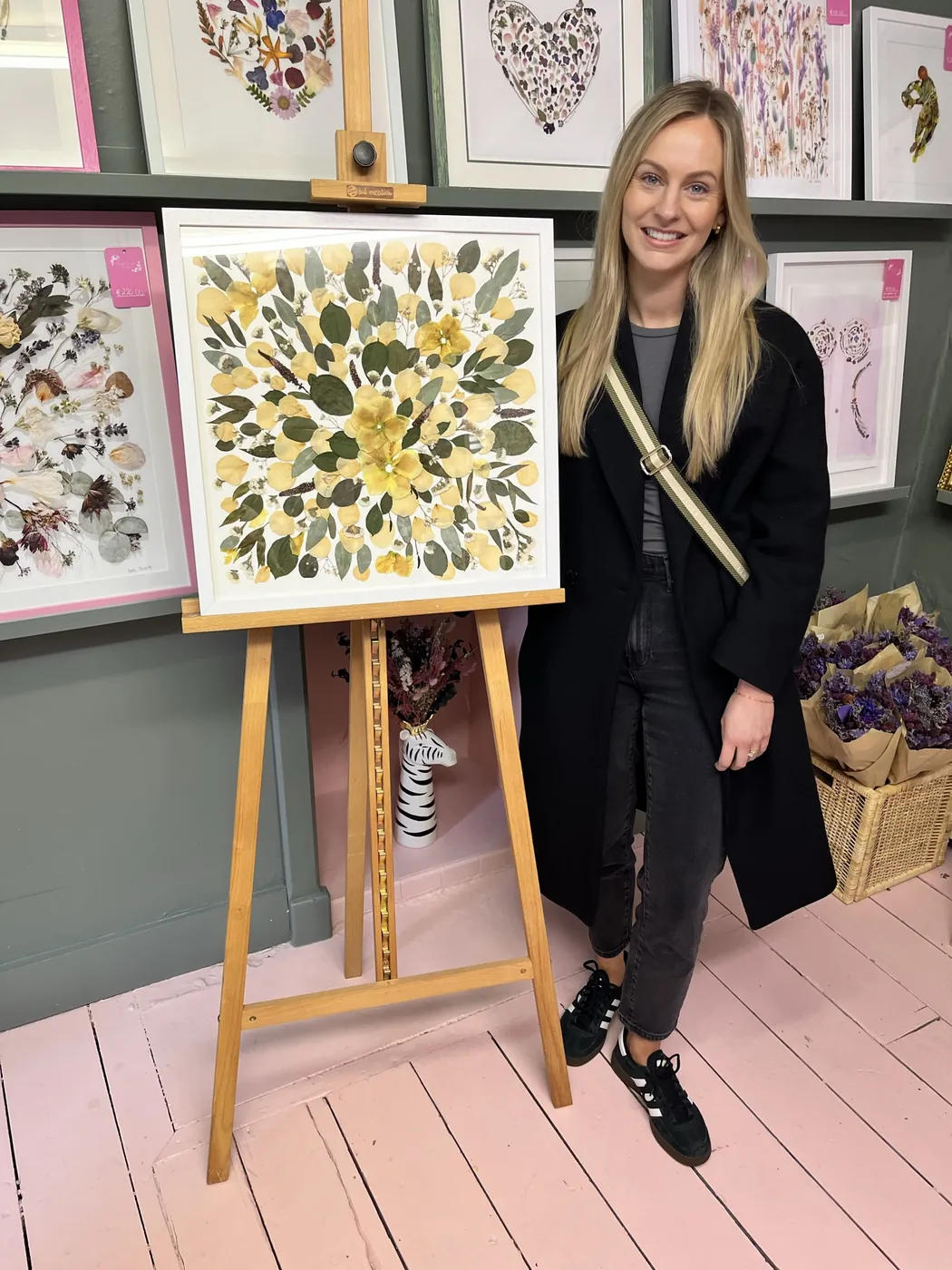 A happy bride with her framed pressed wedding bouquet