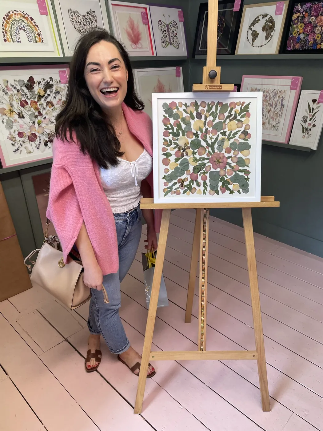 A happy bride with her framed pressed wedding bouquet