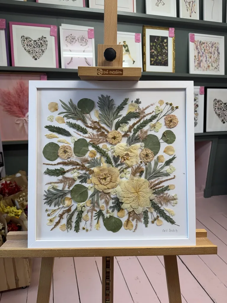A happy bride with her framed pressed wedding bouquet