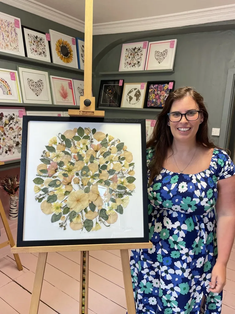 A happy bride with her framed pressed wedding bouquet