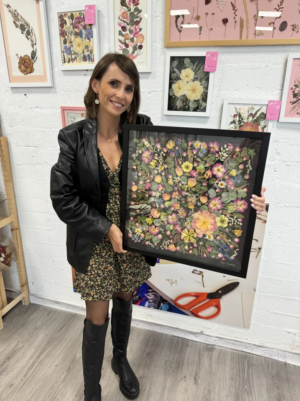 A happy bride with her framed pressed wedding bouquet