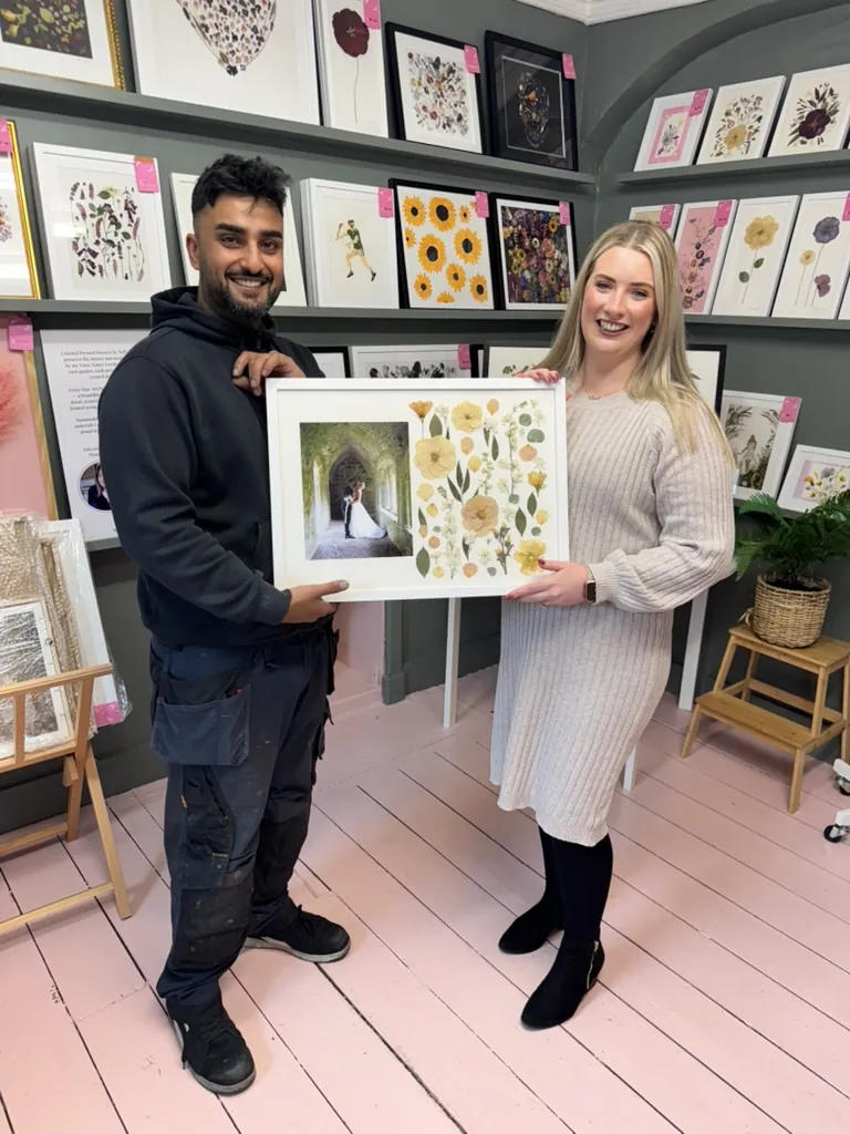 A happy bride with her framed pressed wedding bouquet