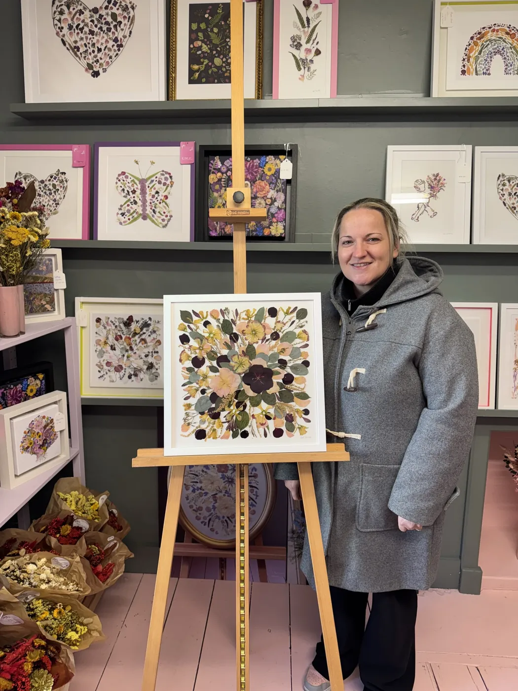 A happy bride with her framed pressed wedding bouquet