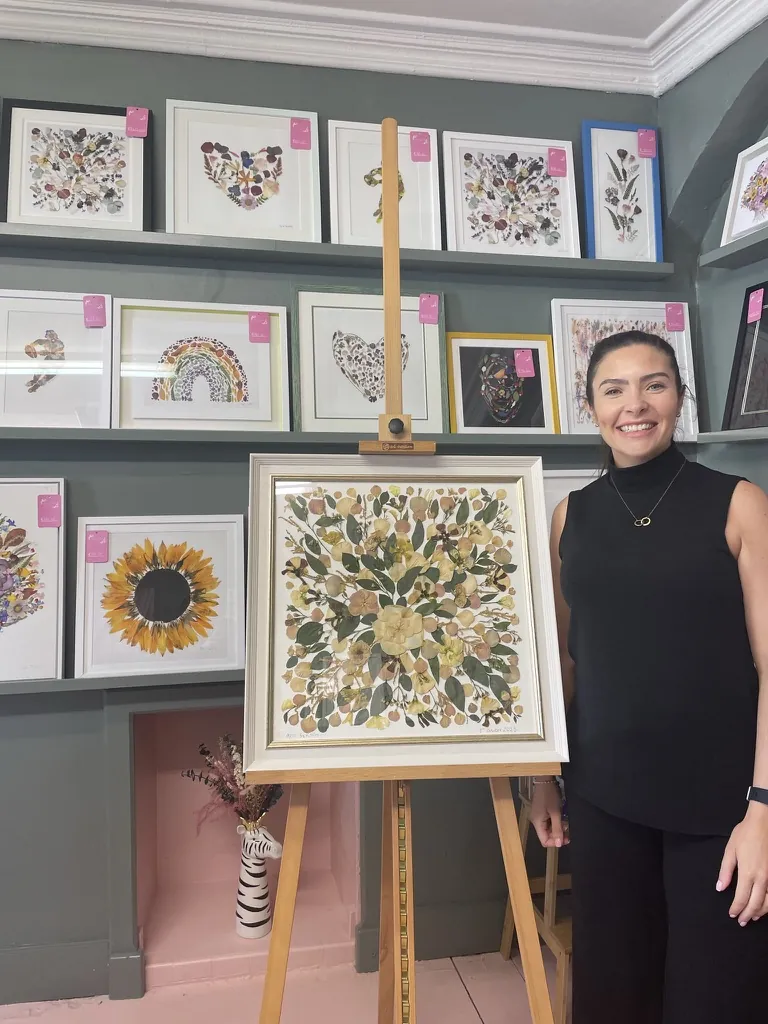 A happy bride with her framed pressed wedding bouquet