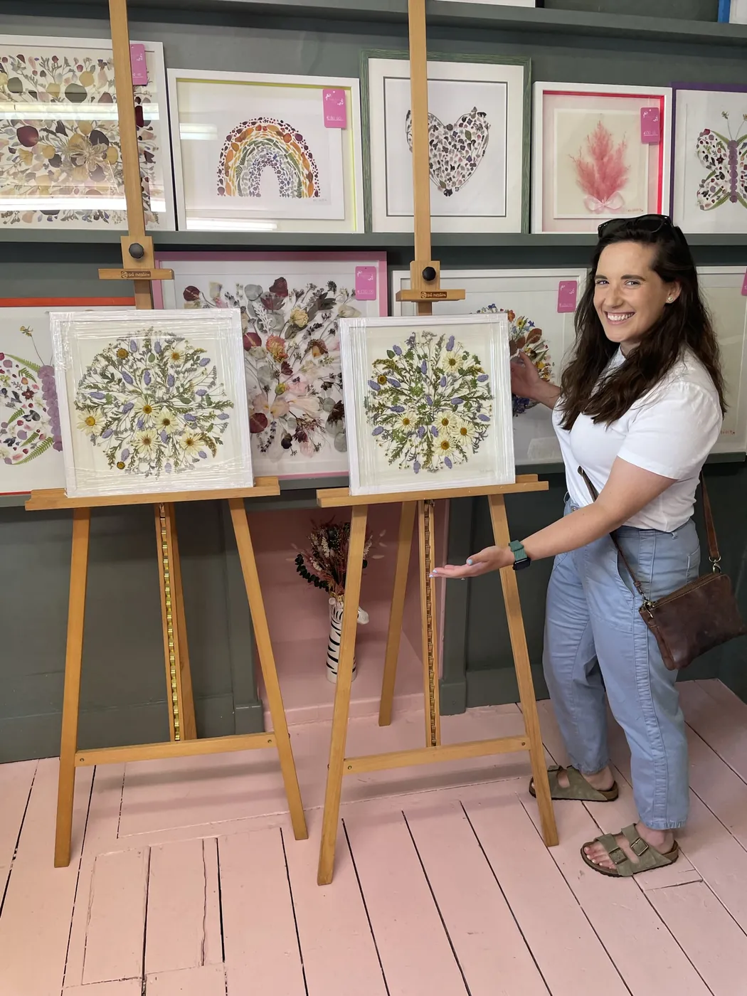 A happy bride with her framed pressed wedding bouquet