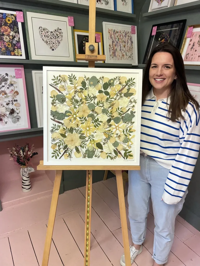 A happy bride with her framed pressed wedding bouquet