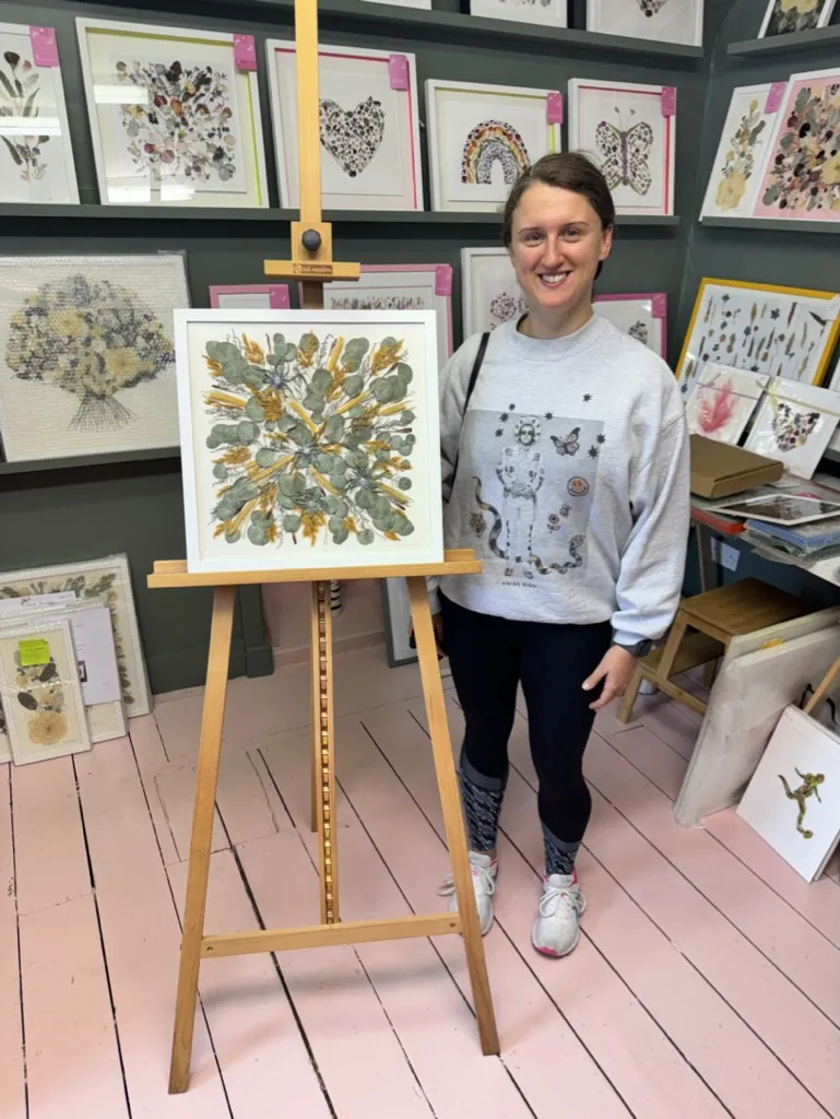 A happy bride with her framed pressed wedding bouquet