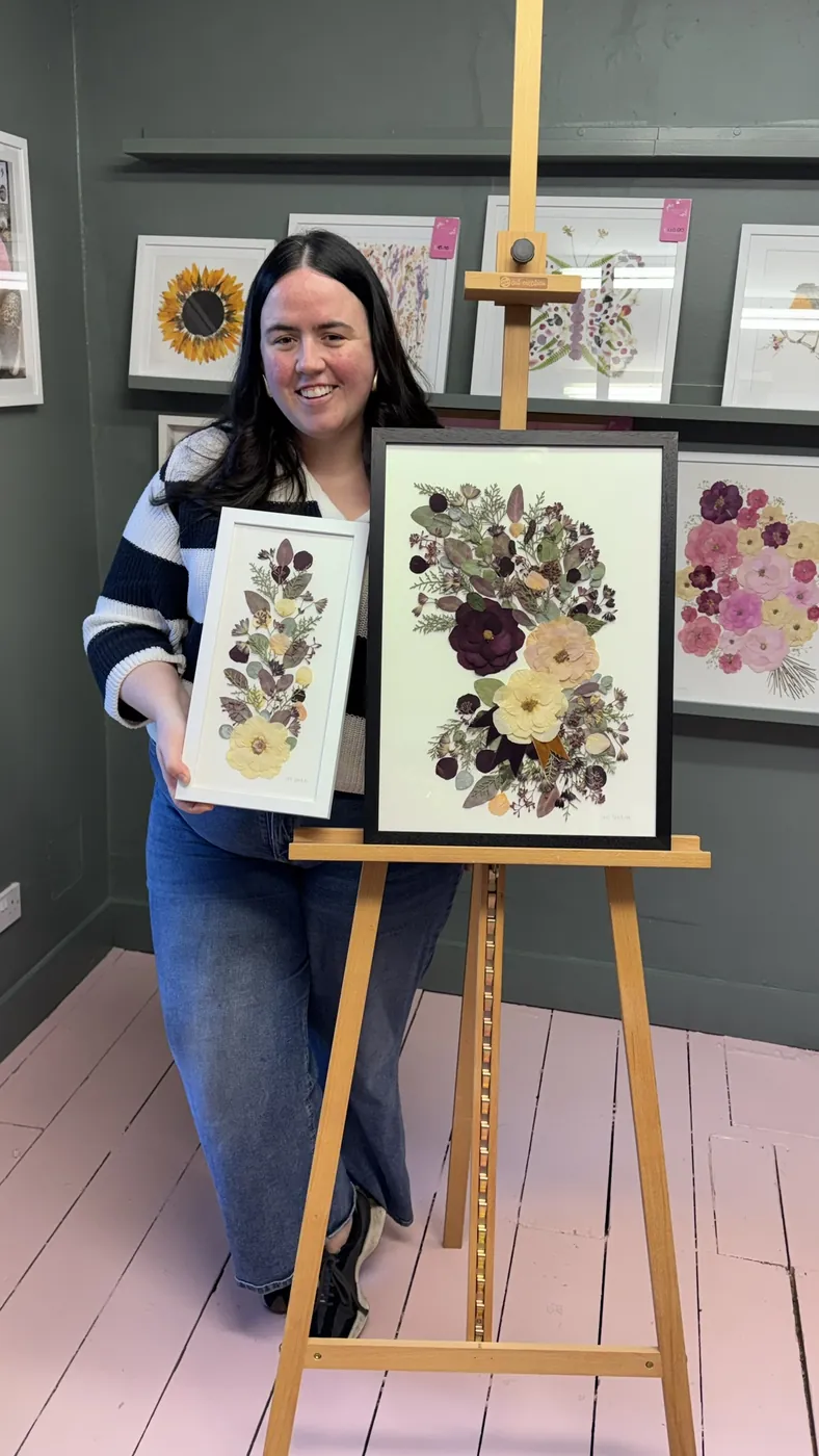 A happy bride with her framed pressed wedding bouquet