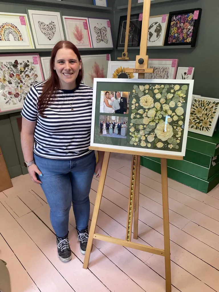 A happy bride with her framed pressed wedding bouquet