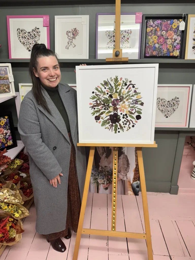 A happy bride with her framed pressed wedding bouquet