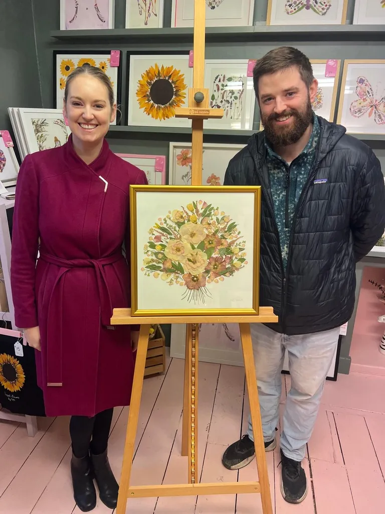 A happy bride with her framed pressed wedding bouquet