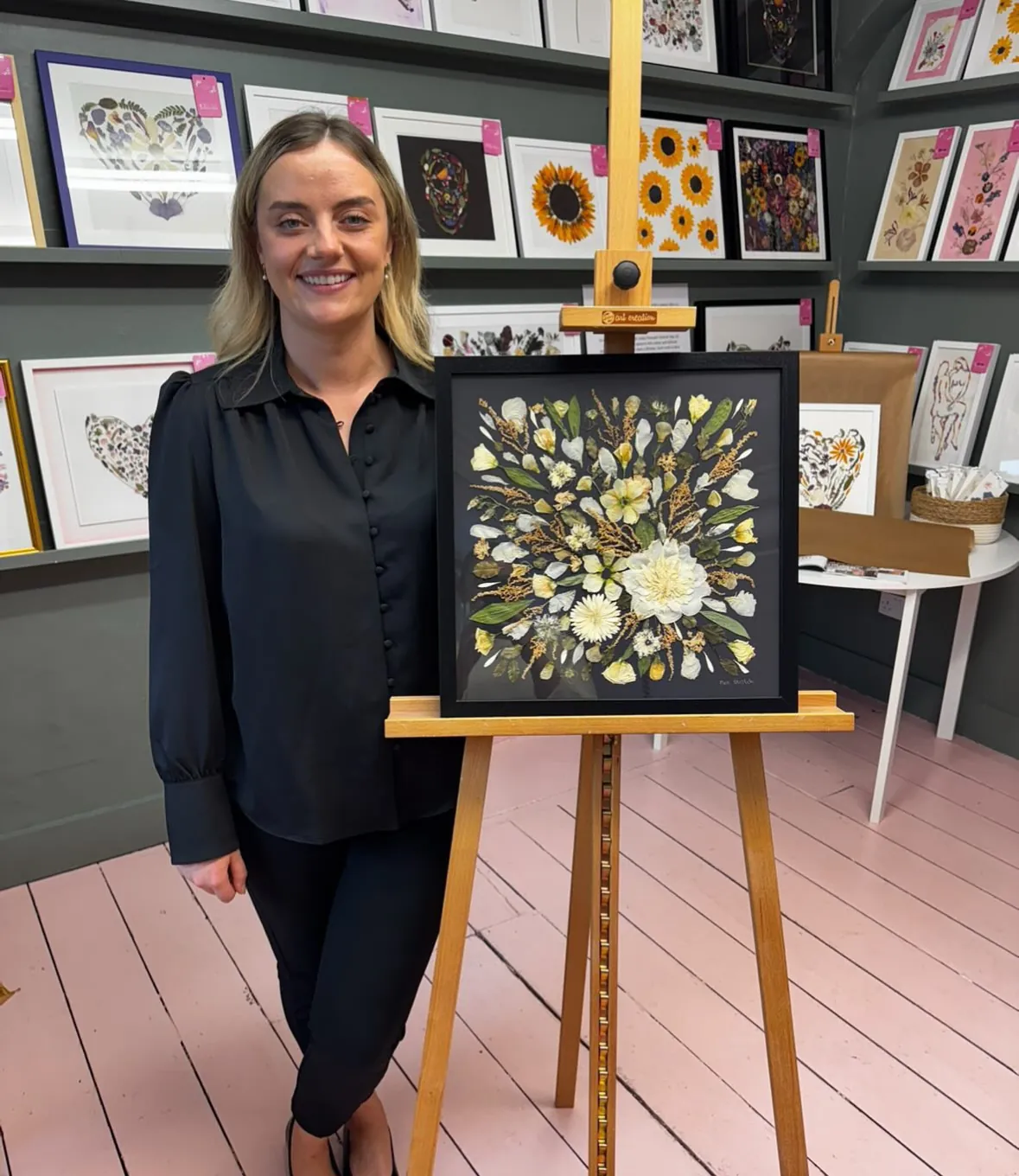 A happy bride with her framed pressed wedding bouquet