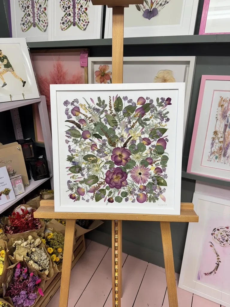 A happy bride with her framed pressed wedding bouquet