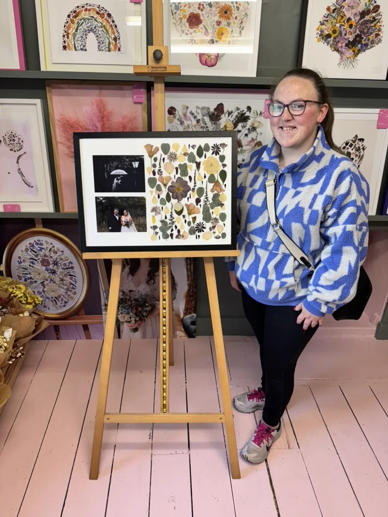 A happy bride with her framed pressed wedding bouquet