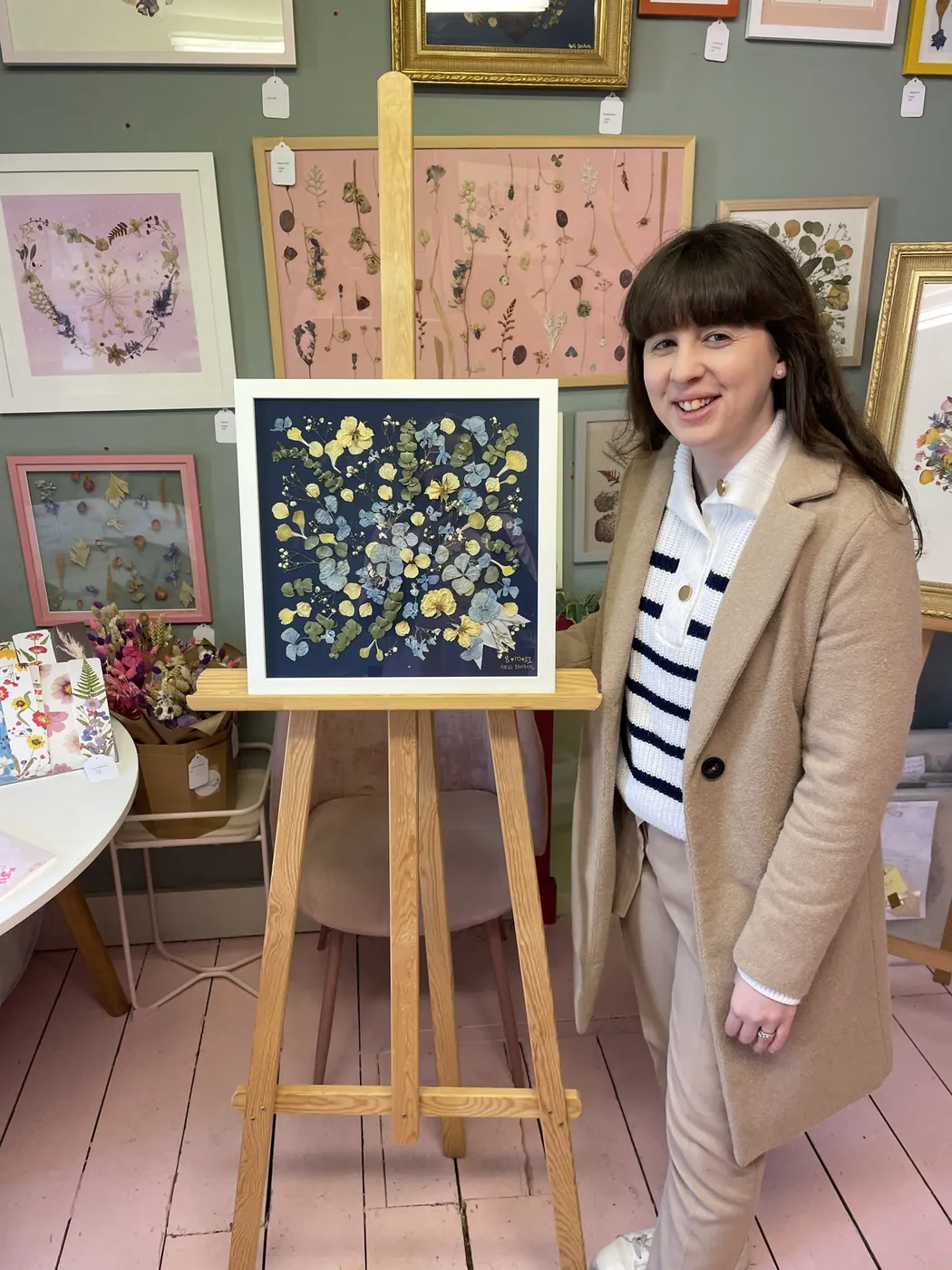 A happy bride with her framed pressed wedding bouquet