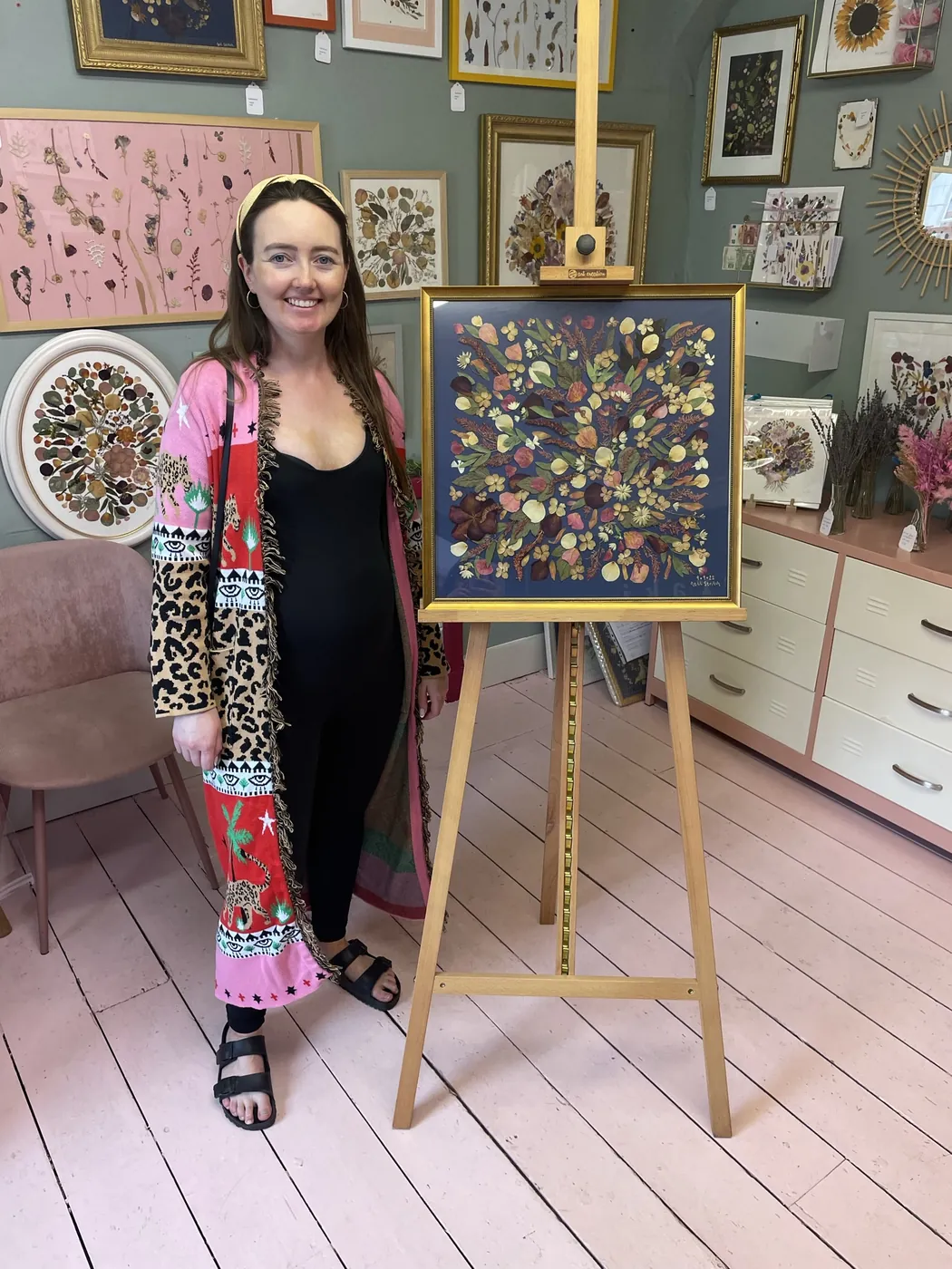 A happy bride with her framed pressed wedding bouquet