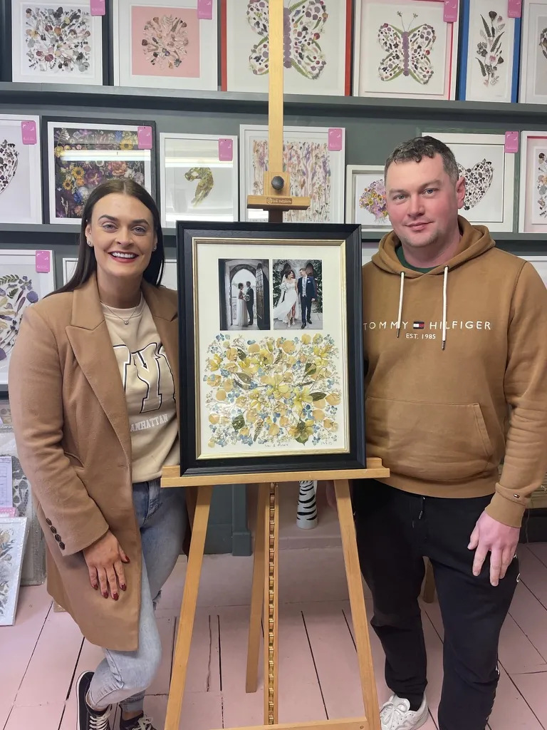 A happy bride with her framed pressed wedding bouquet