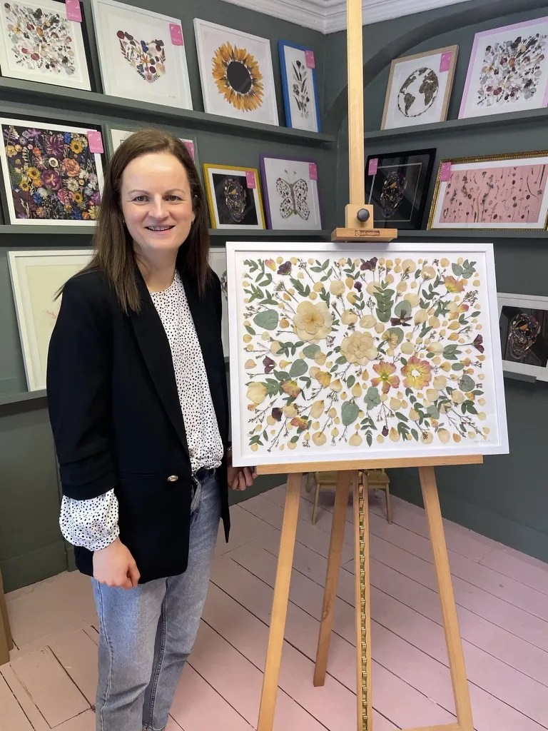 A happy bride with her framed pressed wedding bouquet