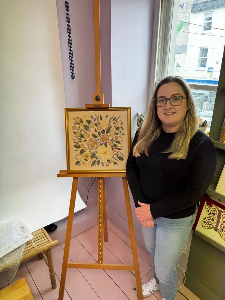 A happy bride with her framed pressed wedding bouquet