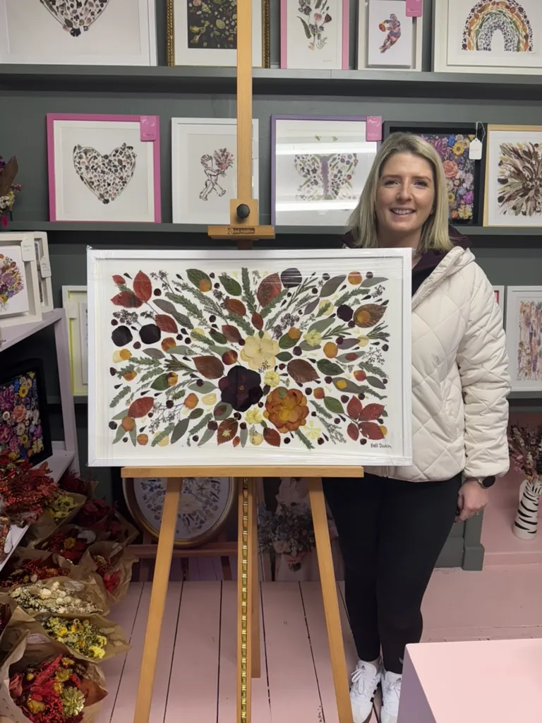 A happy bride with her framed pressed wedding bouquet