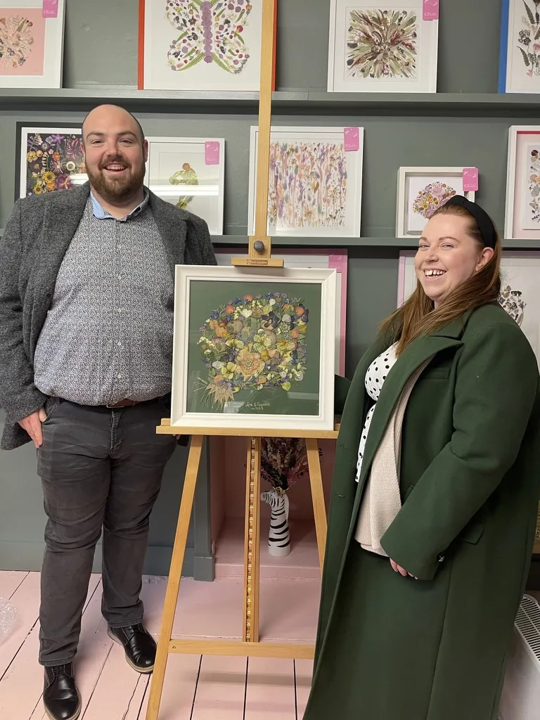 A happy bride with her framed pressed wedding bouquet