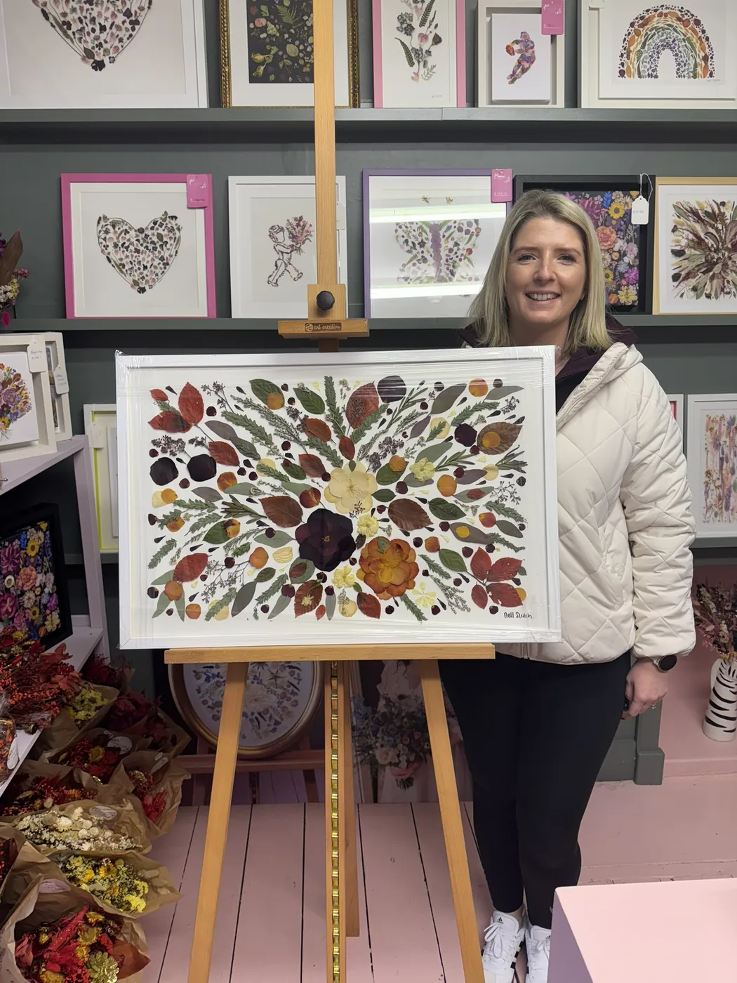 A happy bride with her framed pressed wedding bouquet
