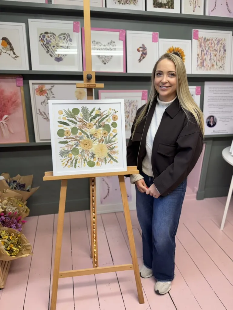 A happy bride with her framed pressed wedding bouquet