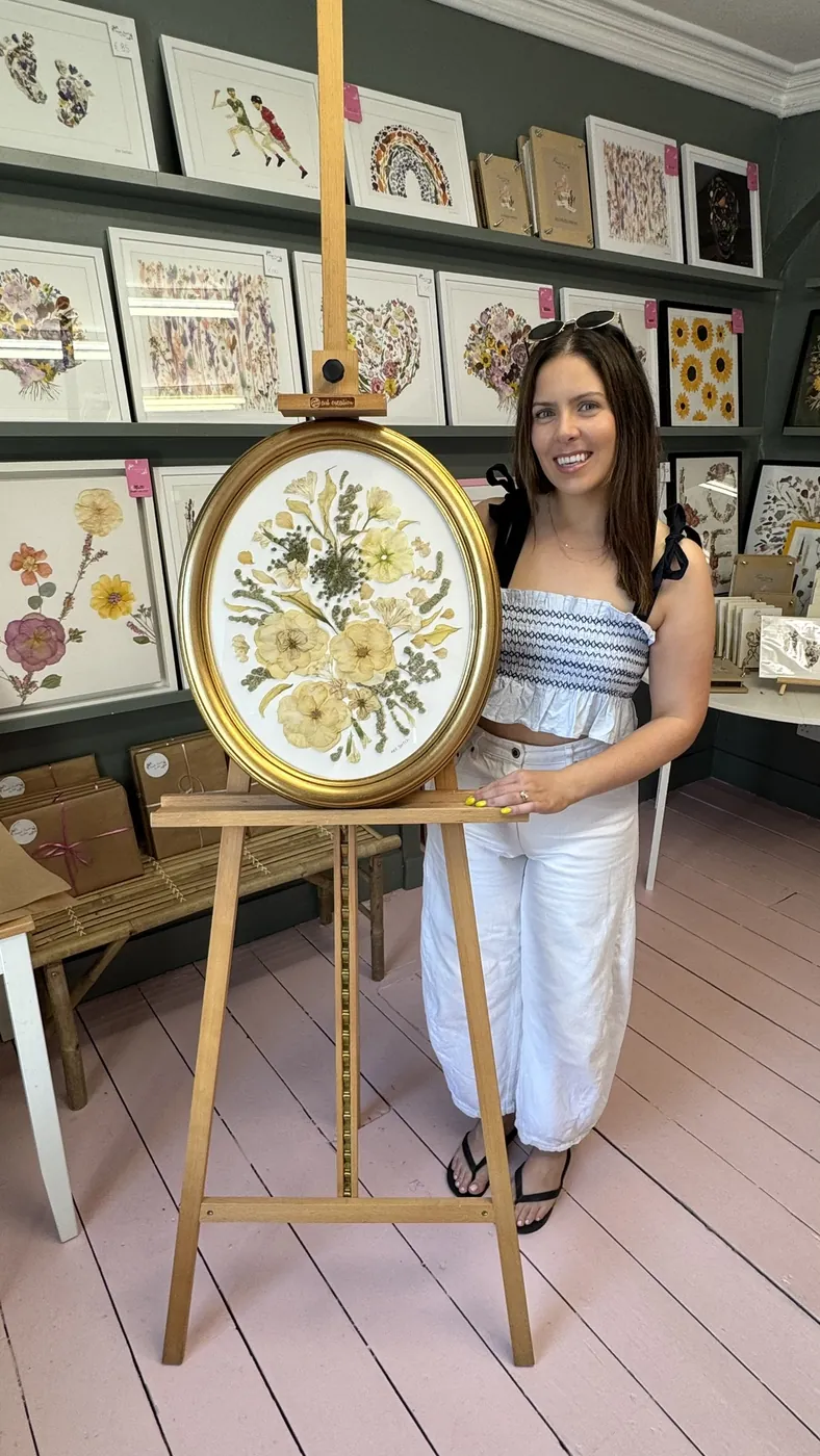 A happy bride with her framed pressed wedding bouquet