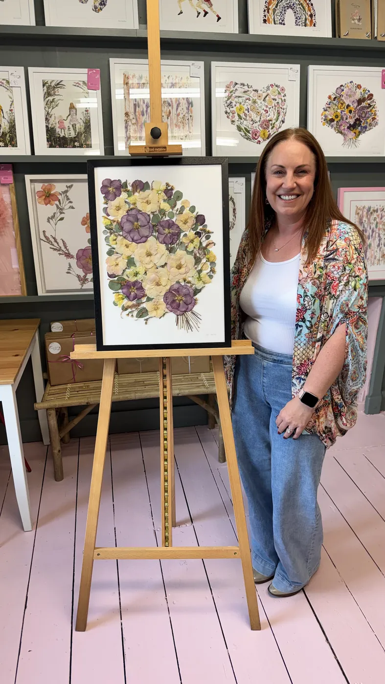 A happy bride with her framed pressed wedding bouquet