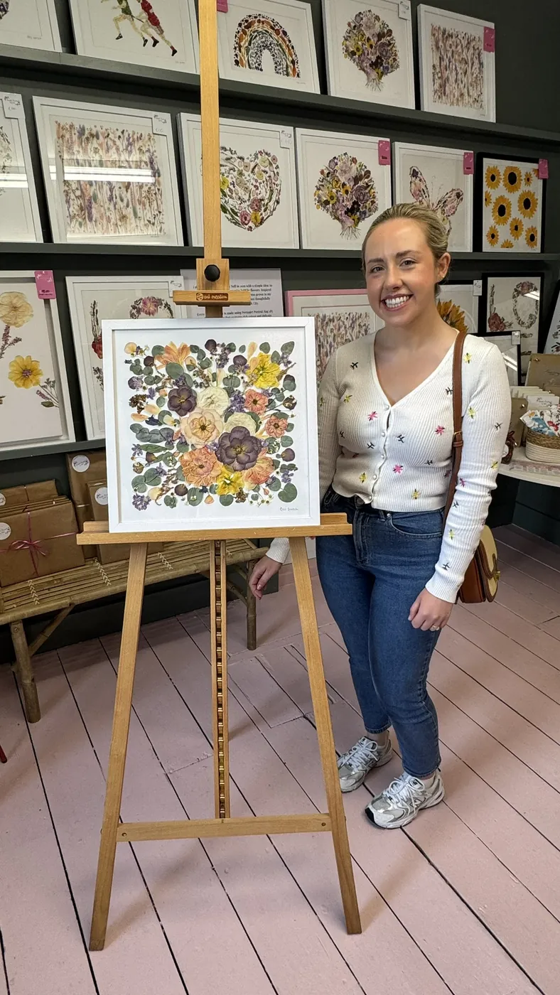 A happy bride with her framed pressed wedding bouquet