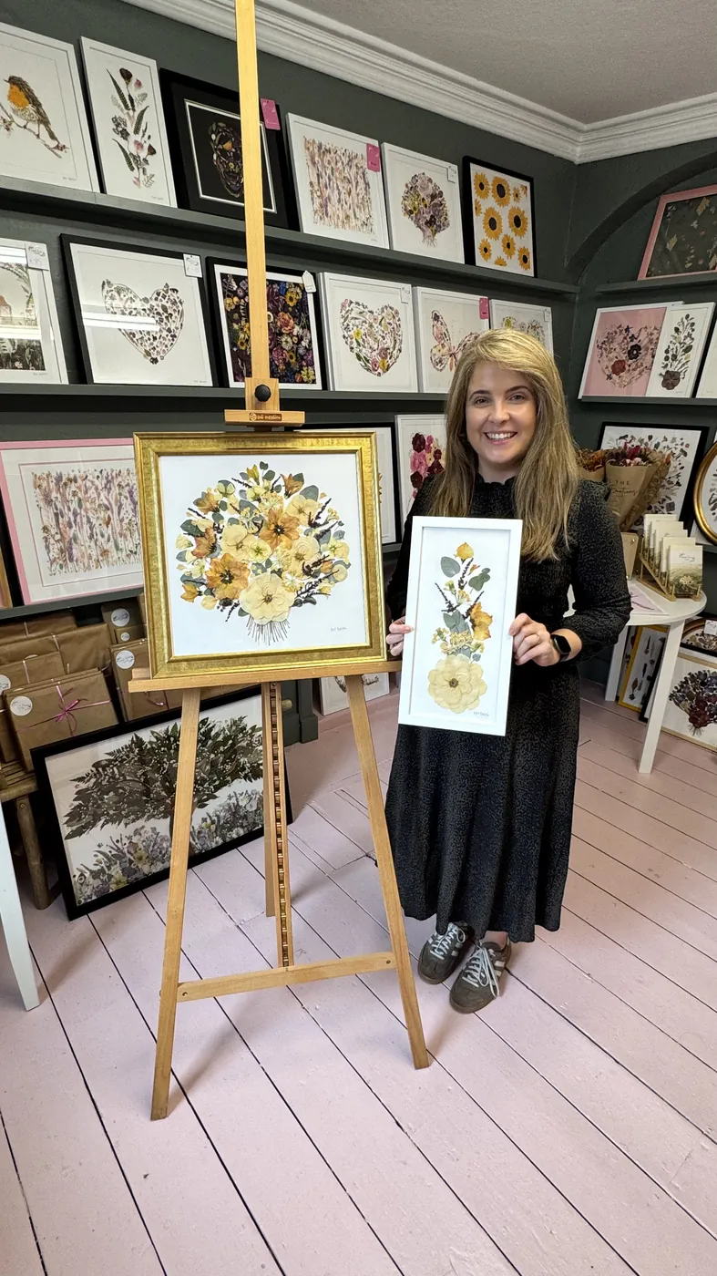 A happy bride with her framed pressed wedding bouquet
