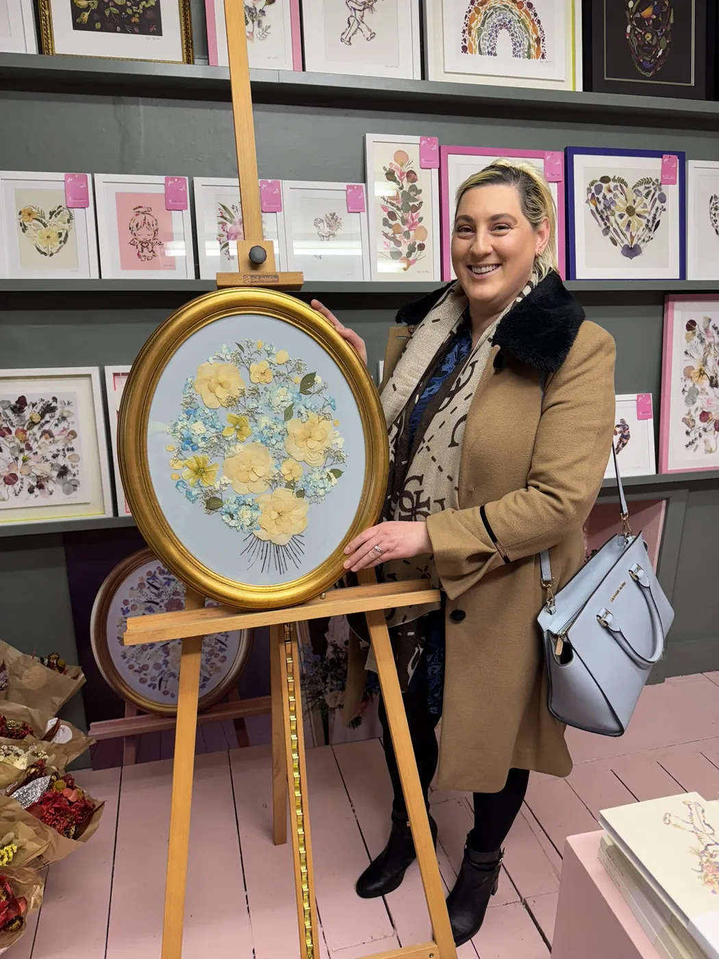 A happy bride with her framed pressed wedding bouquet