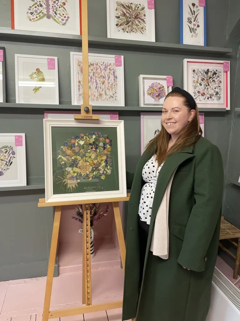 A happy bride with her framed pressed wedding bouquet