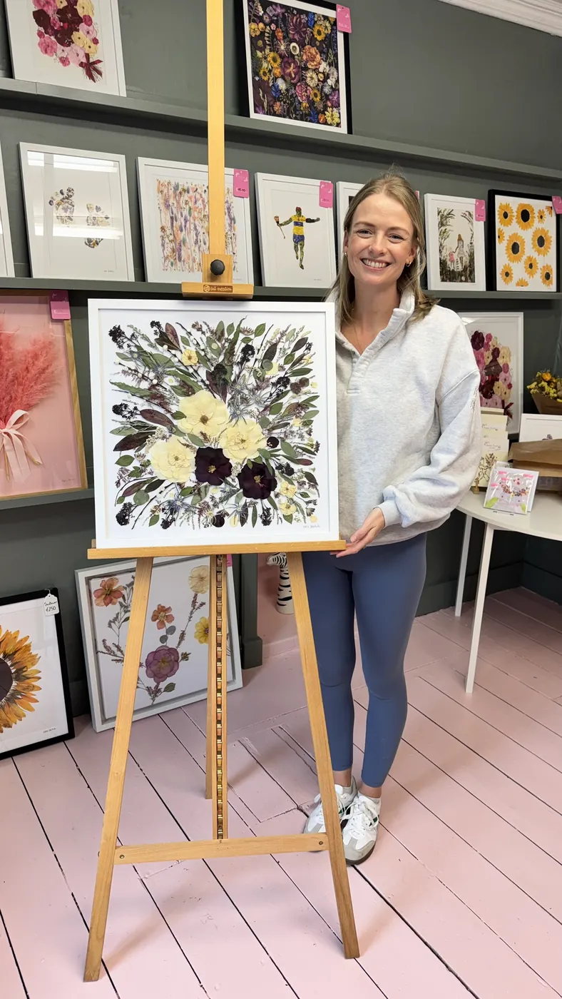 A happy bride with her framed pressed wedding bouquet