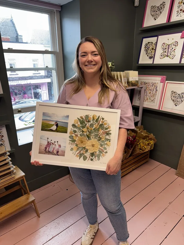 A happy bride with her framed pressed wedding bouquet