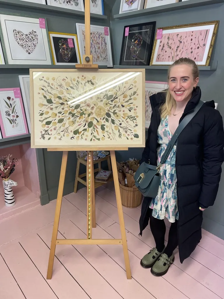 A happy bride with her framed pressed wedding bouquet