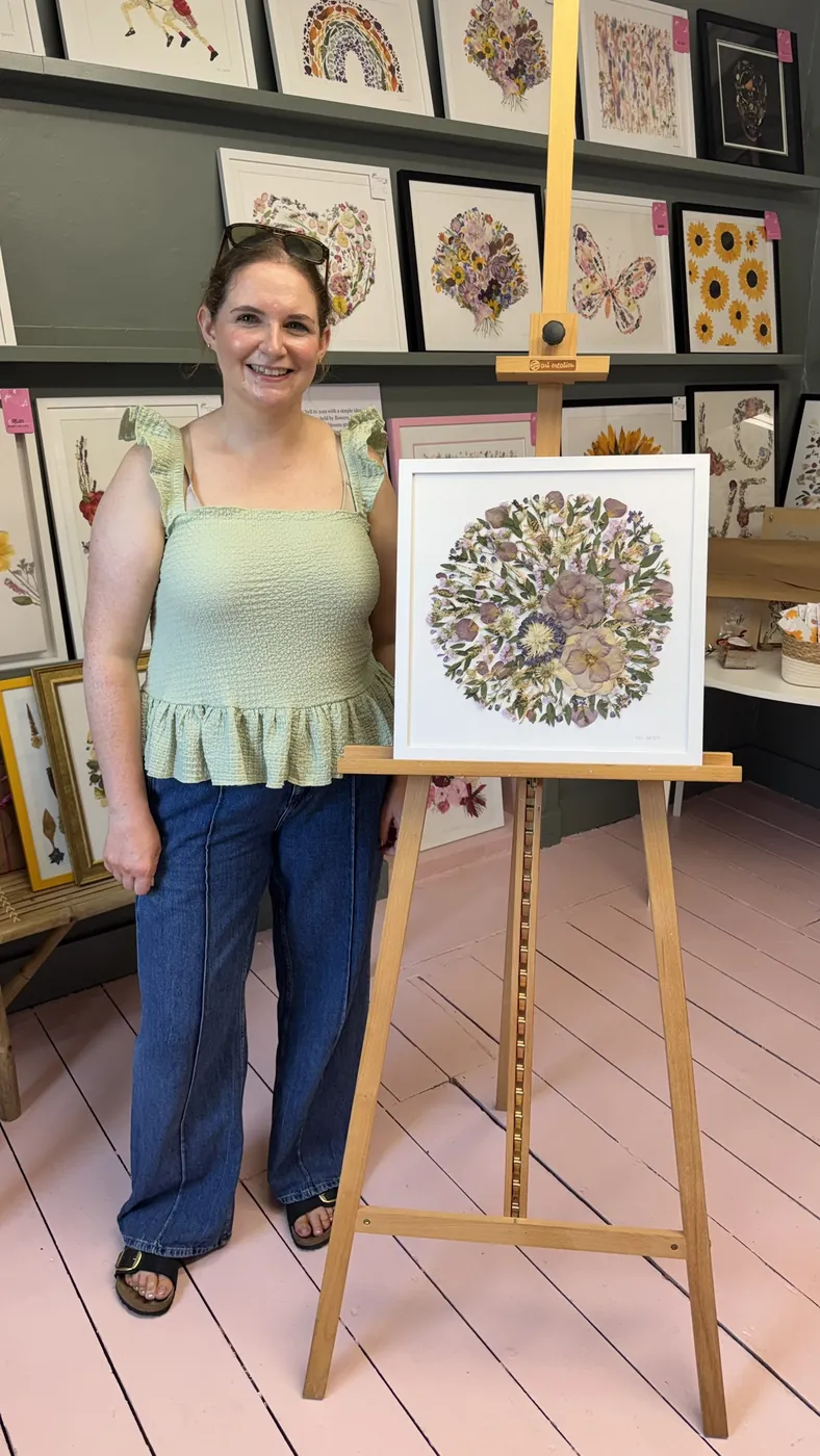 A happy bride with her framed pressed wedding bouquet
