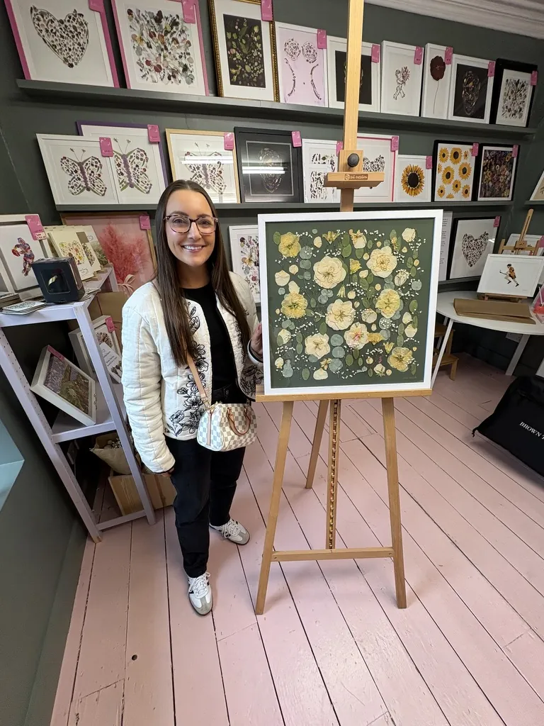 A happy bride with her framed pressed wedding bouquet