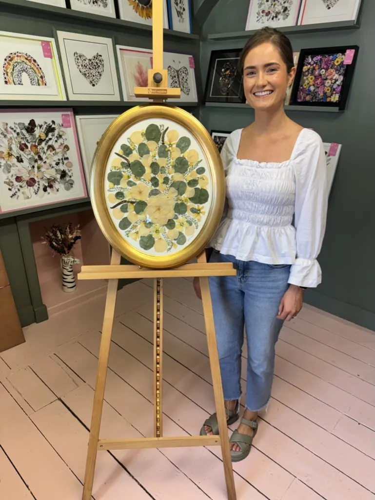 A happy bride with her framed pressed wedding bouquet