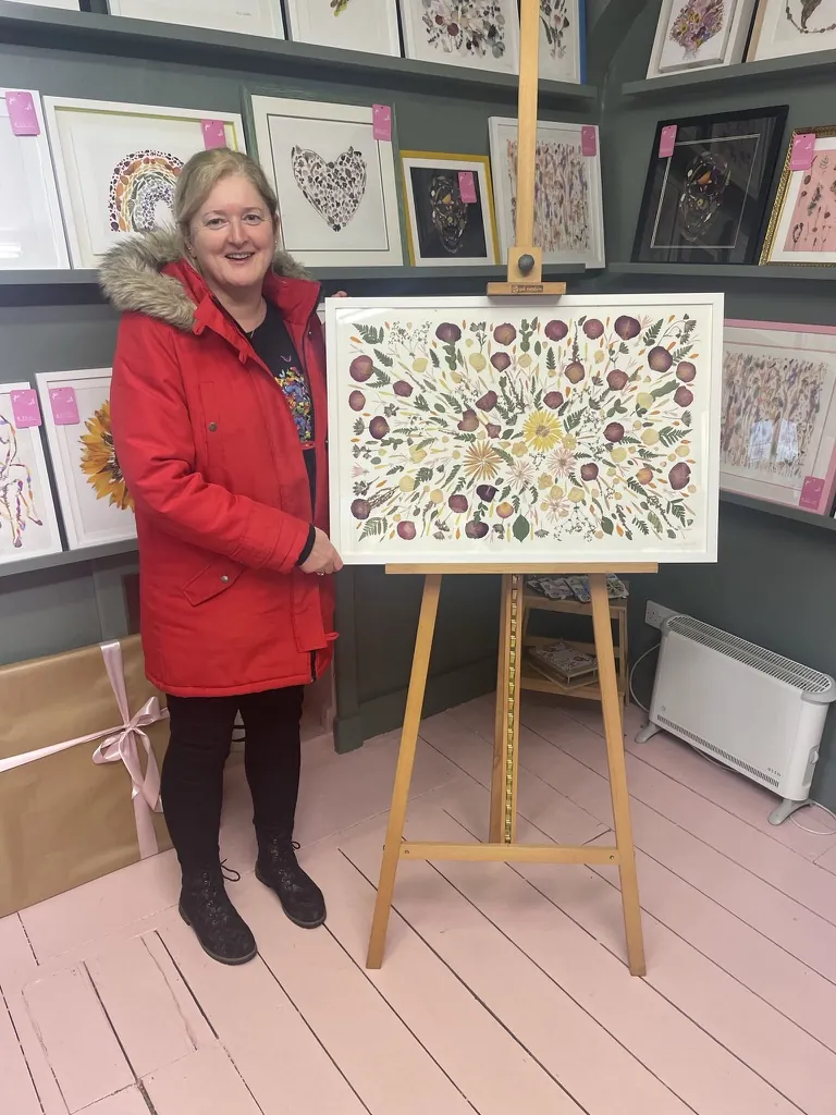 A happy bride with her framed pressed wedding bouquet