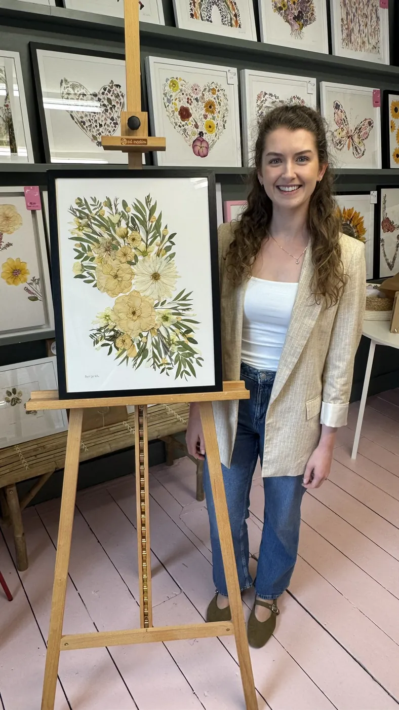 A happy bride with her framed pressed wedding bouquet