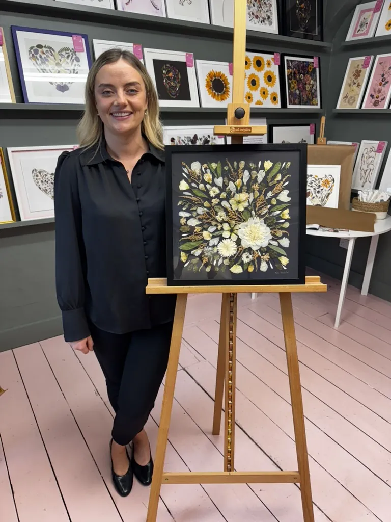 A happy bride with her framed pressed wedding bouquet