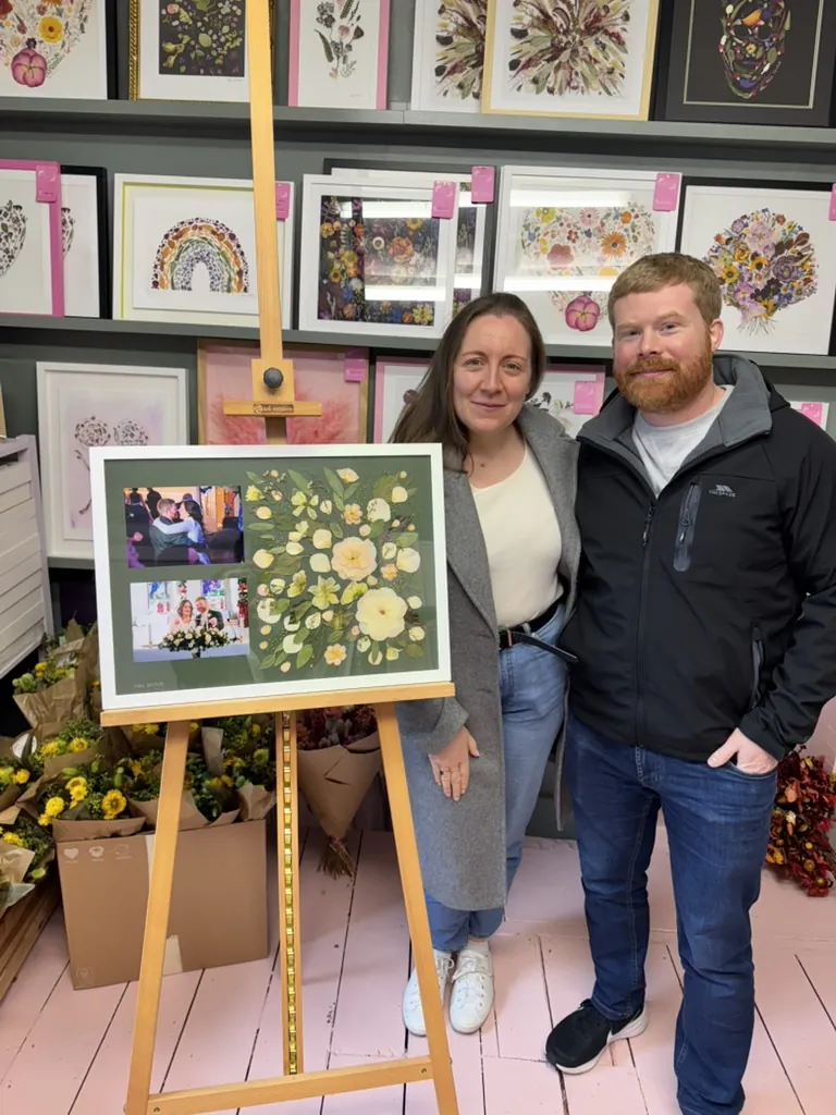 A happy bride with her framed pressed wedding bouquet