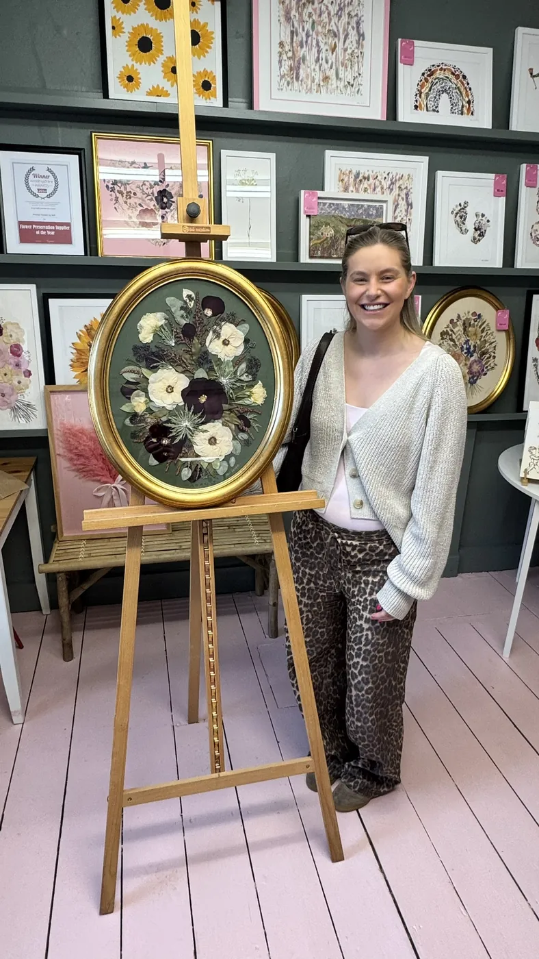 A happy bride with her framed pressed wedding bouquet