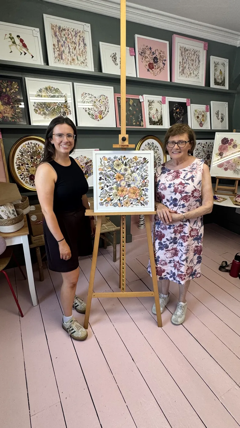 A happy bride with her framed pressed wedding bouquet