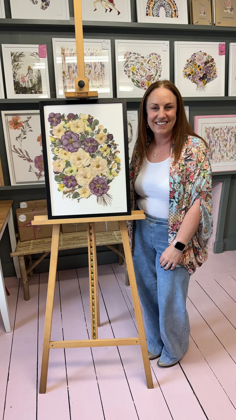 A happy bride with her framed pressed wedding bouquet