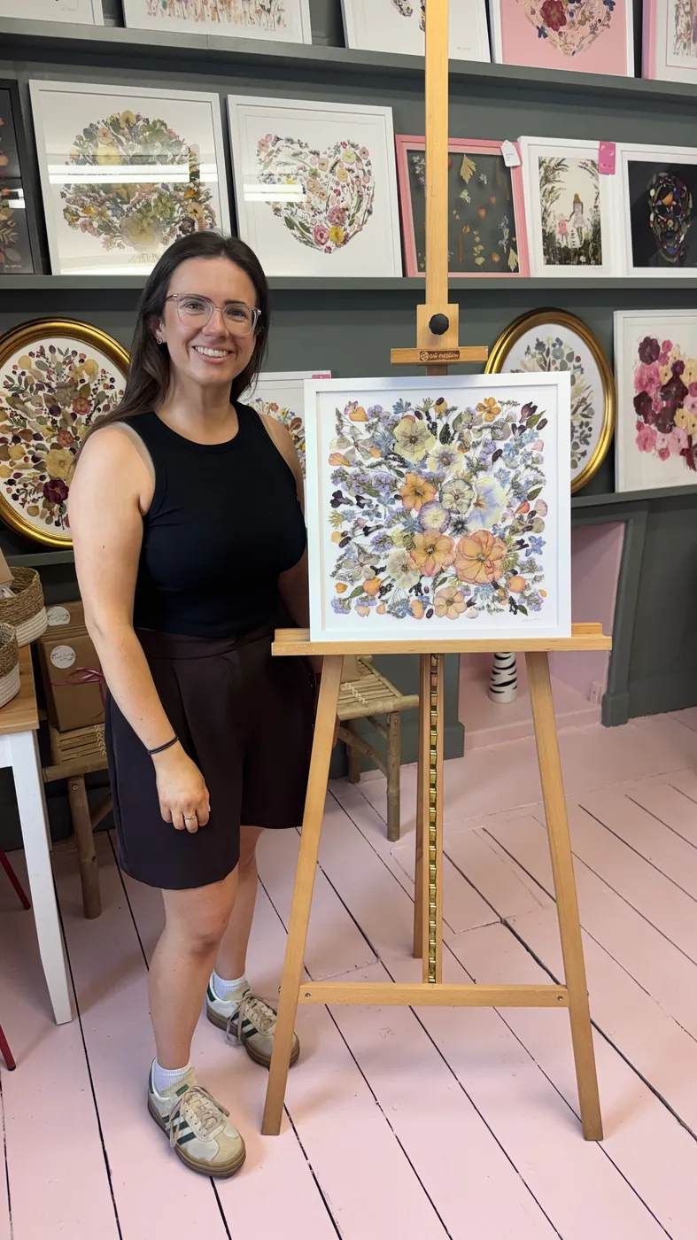 A happy bride with her framed pressed wedding bouquet